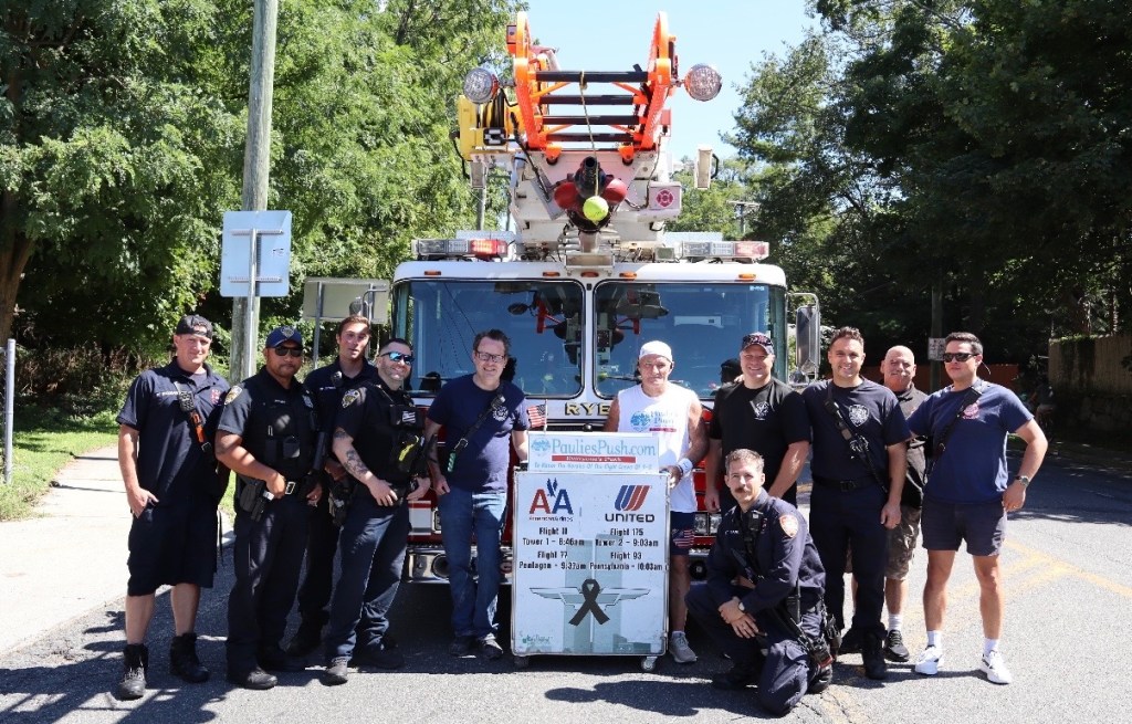 Photo of a group posing for a photo in front of a fire truck.